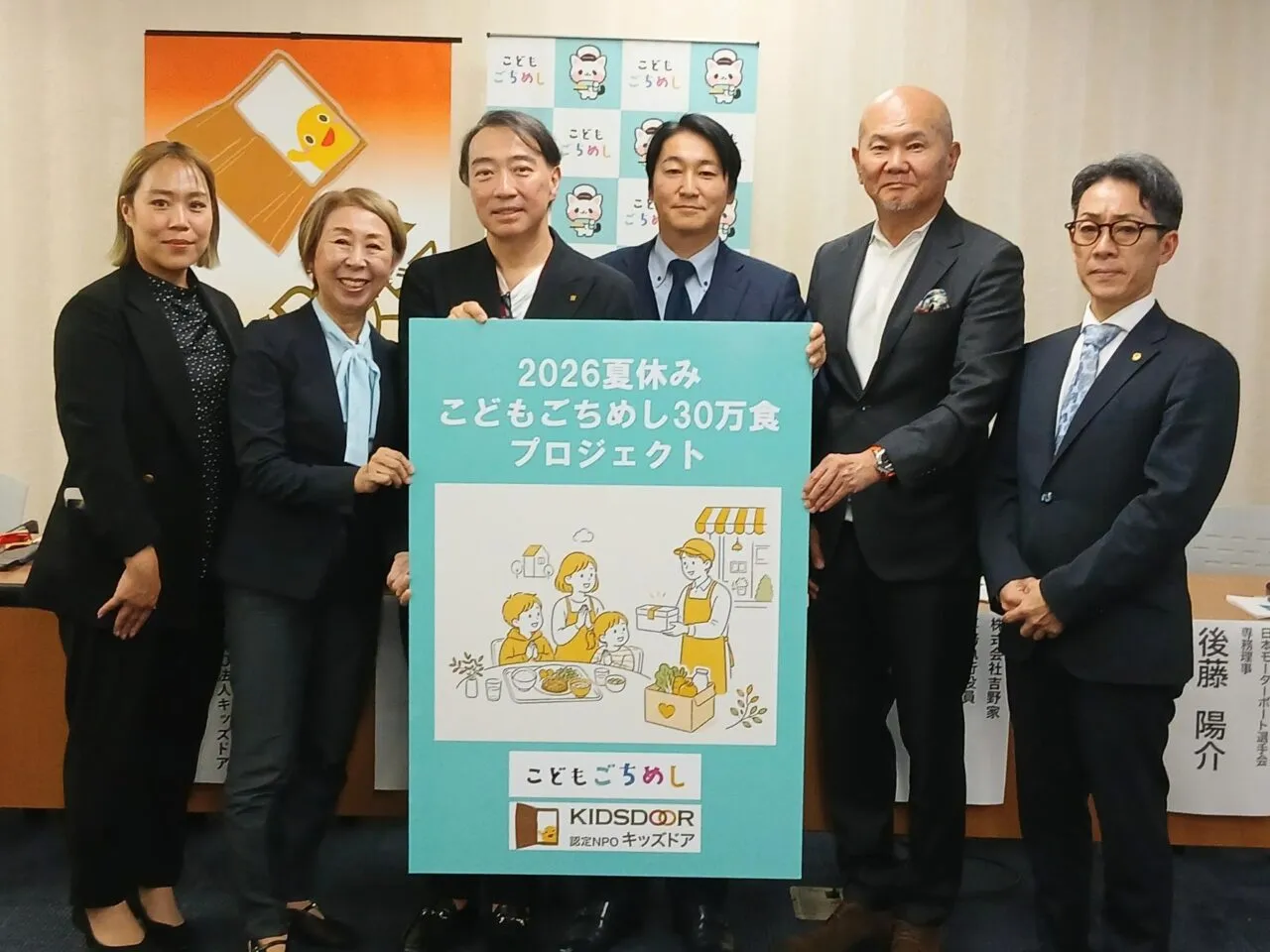 厚生労働省での記者会見で、2026夏休みこどもごちめし30万食プロジェクトのパネルを持つ関係者